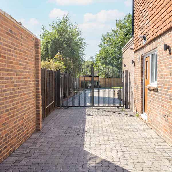 Side view of the building showing the metal security gates that lead to the parking area and rear of the building.