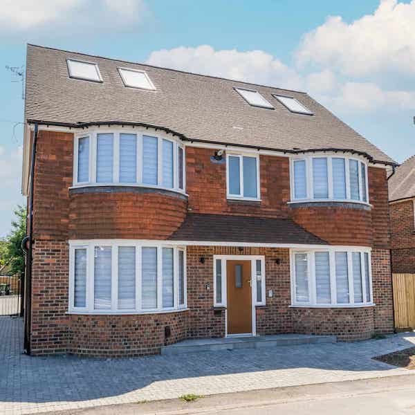 The front view of the building, showing a central front door flanked by bay windows on the ground and first floor levels.